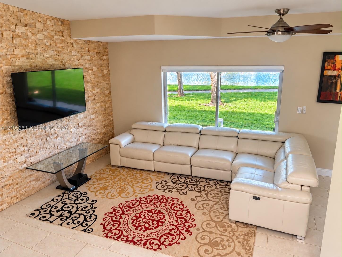 Sala con pared de piedra y vista al lago