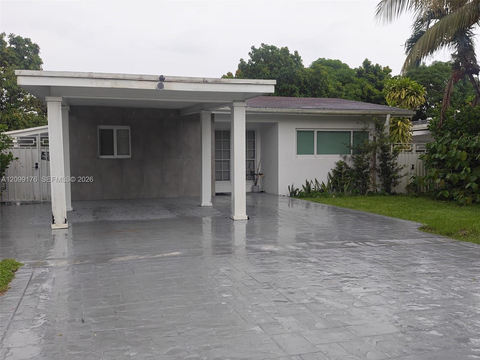 Fachada y cochera techada de la casa